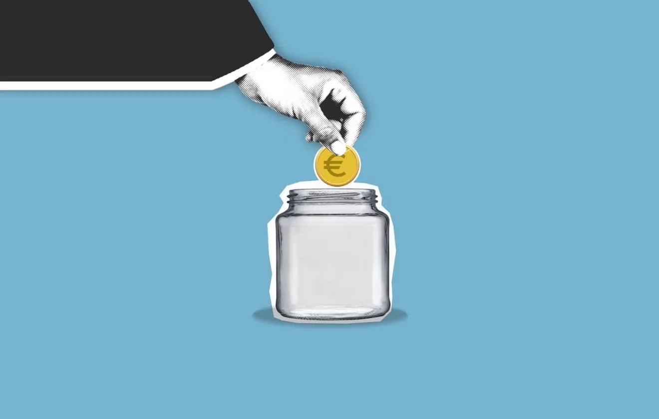 Une main dépose une pièce en euros dans un bocal en verre : l'externalisation dans les services financiers